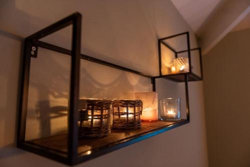a shelf with candles and lights on a wall at Ruim vakantiehuis met mooie tuin op de Veluwe in Putten