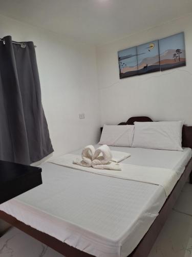 łóżko z ręcznikiem w pokoju w obiekcie Villa Kendra w mieście Moalboal