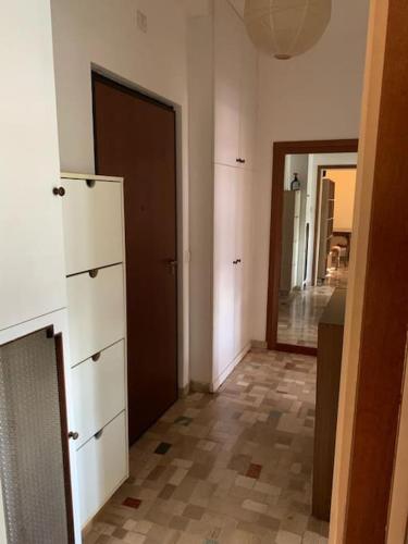 Habitación con pasillo con armarios blancos y puerta. en small panoramic flat in milan en Milán