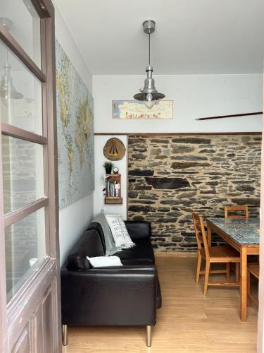 Habitación con sofá de cuero negro y mesa. en Albergue Mayor, en Sarria