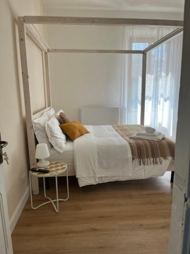 a bedroom with a canopy bed with a side table at Casa Marongiu in Santa Maria la Palma