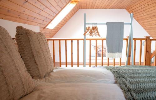 Cama en habitación con techo de madera en Skye Nadair, en Isleornsay