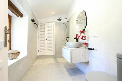 a bathroom with a sink and a mirror at Jaume Romana by Vida Villas in Pollença