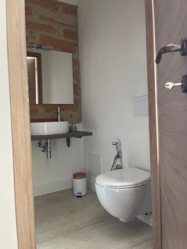 a bathroom with a white toilet and a sink at Casa Marongiu in Santa Maria la Palma