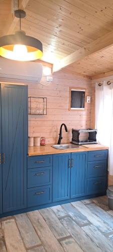 una cocina con armarios azules y fregadero en Imbar relaxing wood log cabin, en Jaffa-Tel Aviv