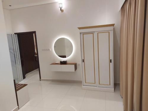 Mabahj Garnatha Hotel Apartments في صحار: غرفة بها باب ومرآة وممر
