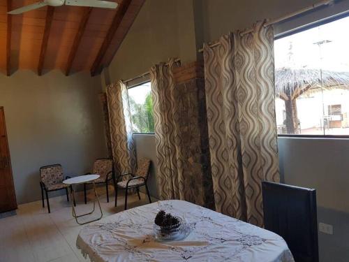jadalnia ze stołem, krzesłami i oknami w obiekcie Departamento Para Hospedaje w mieście San Lorenzo