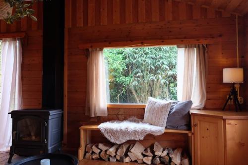 eine Blockhütte mit einem Fenster und einem Herd in der Unterkunft Sfeervol houten huis I Bosrijk Veluwe in Putten