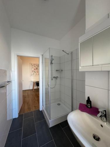 biała łazienka z prysznicem i umywalką w obiekcie 82m2 - 4 Zimmer mitten in Hagen - huge open space w mieście Hagen