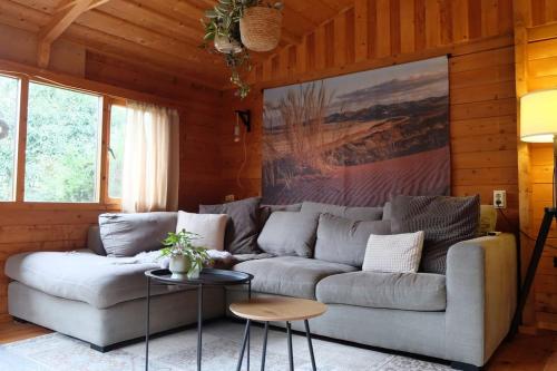 プッテンにあるSfeervol houten huis I Bosrijk Veluweのソファとテーブルのあるリビングルーム