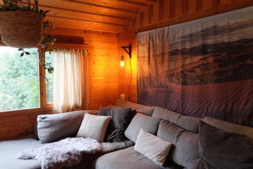 a living room with a couch and a window at Sfeervol houten huis I Bosrijk Veluwe in Putten
