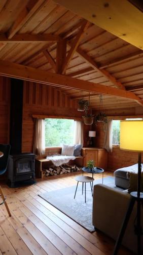 a living room with a couch and a fireplace at Sfeervol houten huis I Bosrijk Veluwe in Putten