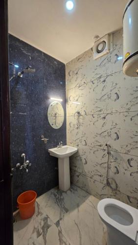 La salle de bains est pourvue de toilettes blanches et d'un lavabo. dans l'établissement New Hotel Meghdoot, à Srinagar