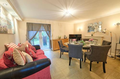 a living room with a couch and a dining room at Bespoke Bungalow Salford Quays - Garden, WiFi and Parking in Manchester