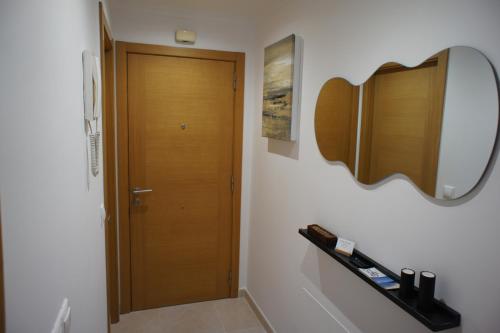 baño con puerta de madera y estante en Alojamientos Viveiro - Playa de Covas I, en Viveiro