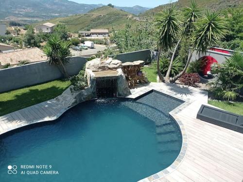 - une grande piscine avec une fontaine dans la cour dans l'établissement Appartement F2 dessous de villa, à Olmeta-di-Tuda