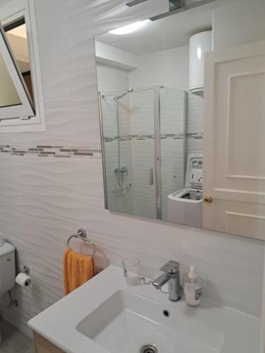 a white bathroom with a sink and a mirror at Apartamento PinkFloyd im Palm Garden in Morro del Jable