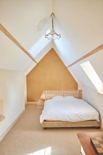 une chambre avec un lit et un plafond dans l'établissement Ferme de Franqueville, à Sainte-Marie-du-Mont