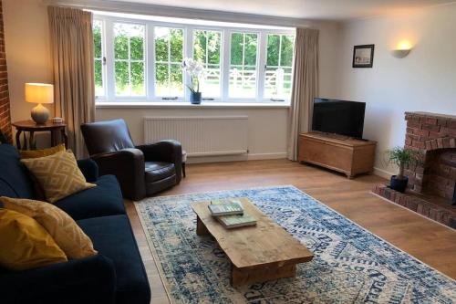 a living room with a couch and a coffee table at Stablehurst Cottage in West Hoathley