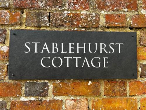 a sign on a brick wall with the words stritch outpost cottage at Stablehurst Cottage in West Hoathley