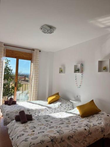 two beds in a room with a window at Apartamento Mezquita Caudiel in Caudiel