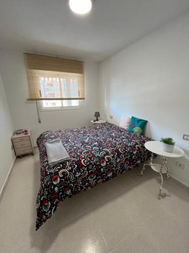 ein Schlafzimmer mit einem großen Bett und einem Tisch in der Unterkunft Apartamento a pie de playa con vistas al mar y piscina in Benicàssim