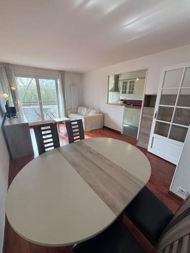 une table blanche et des chaises dans un salon dans l'établissement F3 avec balcon 5 min gare SQY et Parking gratuit, à Guyancourt