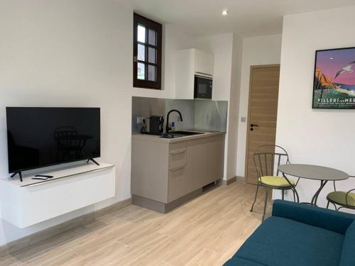 Il comprend un salon doté d'une télévision, d'une table et d'une cuisine. dans l'établissement Le Méridien, studio rénové avec terrasse, 8 min à pieds du centre ville, à Villers-sur-Mer
