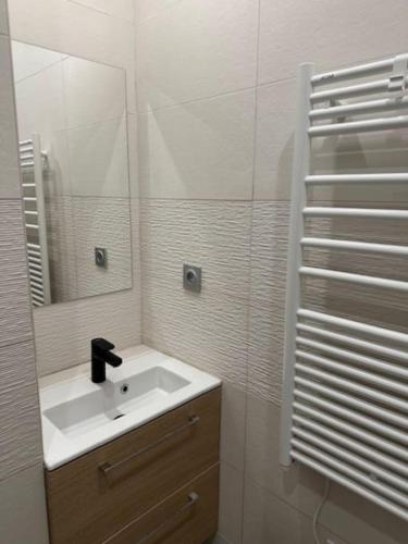 une salle de bain avec un lavabo et un miroir dans l'établissement Le Méridien, studio rénové avec terrasse, 8 min à pieds du centre ville, à Villers-sur-Mer