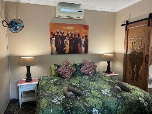 a bedroom with a bed with a painting on the wall at Manzini Chalets 8-9-10-37 in St Lucia