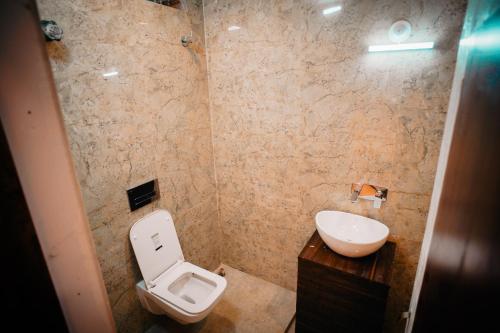 Hotel Asha Inn في Jasidih: حمام مع مرحاض ومغسلة