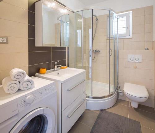 uma casa de banho com uma máquina de lavar roupa e um chuveiro em Apartments Vista Bol em Bol