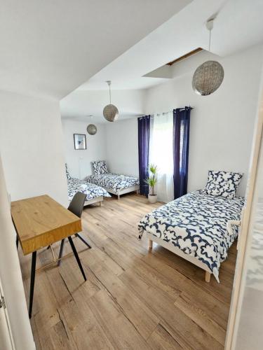 een slaapkamer met 2 bedden en een houten tafel bij Appartement cosy près de Douai in Flers-en-Escribeus