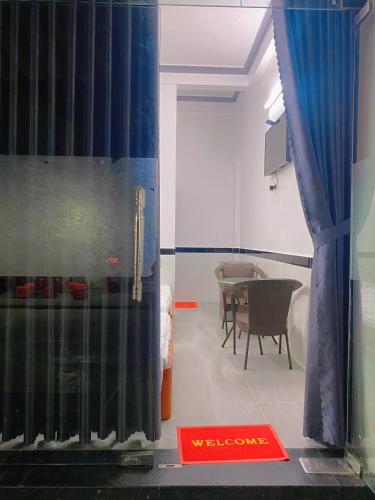 a room with a table and a blue curtain at Nhà Nghỉ Ánh Ngọc in Hue