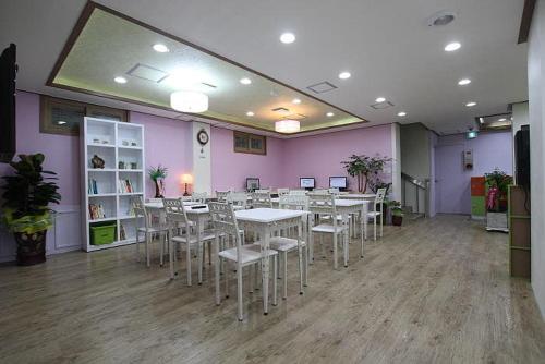 jadalnia ze stołami i krzesłami oraz fioletowymi ścianami w obiekcie Gyeongju Friend Guesthouse w mieście Gyeongju