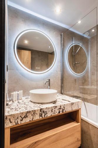 a bathroom with a sink and a mirror at Hotel Les Mélèzes in Les Deux Alpes