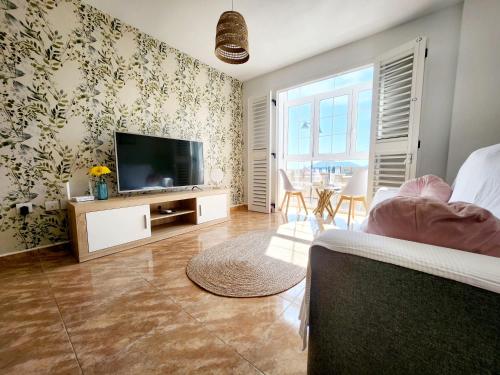 sala de estar con TV de pantalla plana en la pared en Apartamento Rincón del Mar, en Cartagena