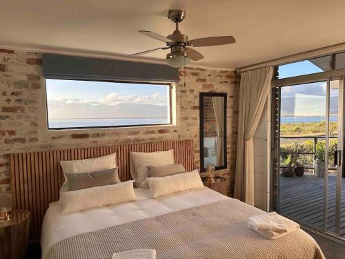 a bedroom with a large bed and a balcony at Seaway Sunsets Relax & Enjoy the calmness with Lagoon & Sea views in Fisherhaven