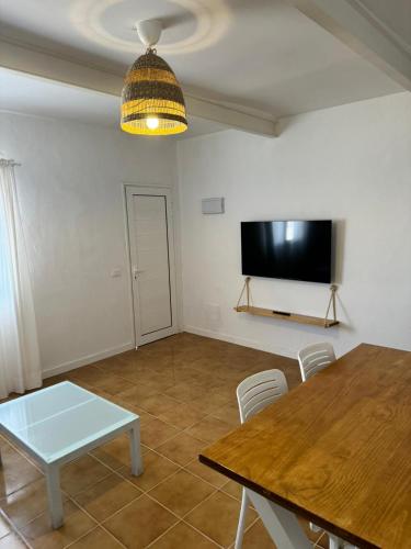 sala de estar con mesa y TV de pantalla plana en Apartamento Chapaleta, en Caleta de Sebo