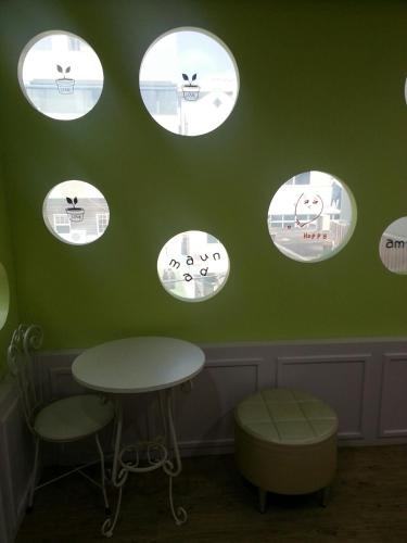 a green room with four circular windows on the wall at Gyeongju Friend Guesthouse in Gyeongju