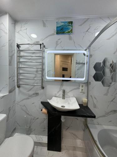 a bathroom with a sink and a toilet and a mirror at LAV Rose Valley Flat&Terrace in Chişinău