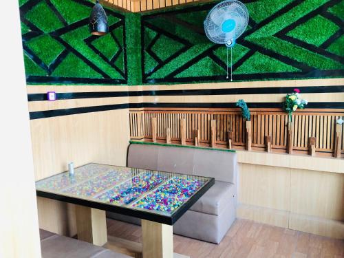 a table in a room with a green wall at Sara's Backpackers Hotel in Kathmandu