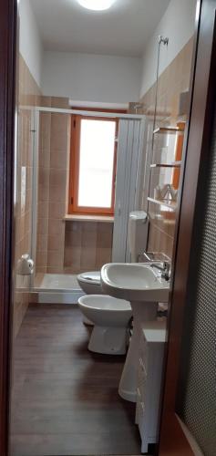 bagno con 2 servizi igienici, lavandino e vasca di Casa Quokka a Meana di Susa