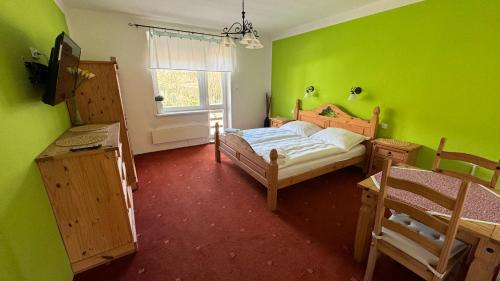 a green room with two beds and a window at Penzion Janoštík in Rožnov pod Radhoštěm
