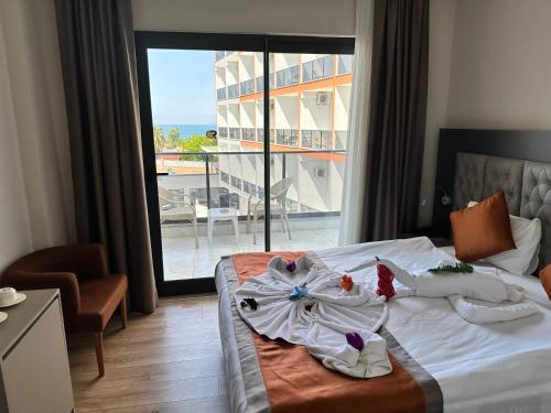 シダにあるSiDE GOLDEN ROCK HOTEL&SPAのベッドと大きな窓が備わるホテルルームです。