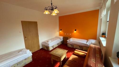 a hotel room with two beds and a table at Penzion Janoštík in Rožnov pod Radhoštěm