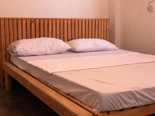 - un lit avec des draps et des oreillers blancs dans l'établissement Art House LU, à San Fernando