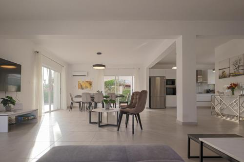 uma sala de estar com paredes brancas e uma mesa e cadeiras em Grand Villa Baci em Coral Bay