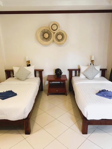 a room with two beds and a mirror on the wall at Wind Beach Resort in Koh Tao