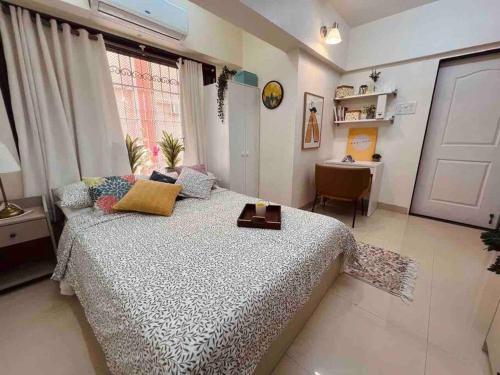 a bedroom with a large bed and a desk at Dawn - A Spacious Modern Studio in Bandra at Almeida Park by Connekt Homes in Mumbai